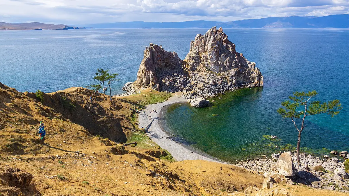 Скала Шаманка над бирюзовой водой Байкала и галечный пляж у Ольхона